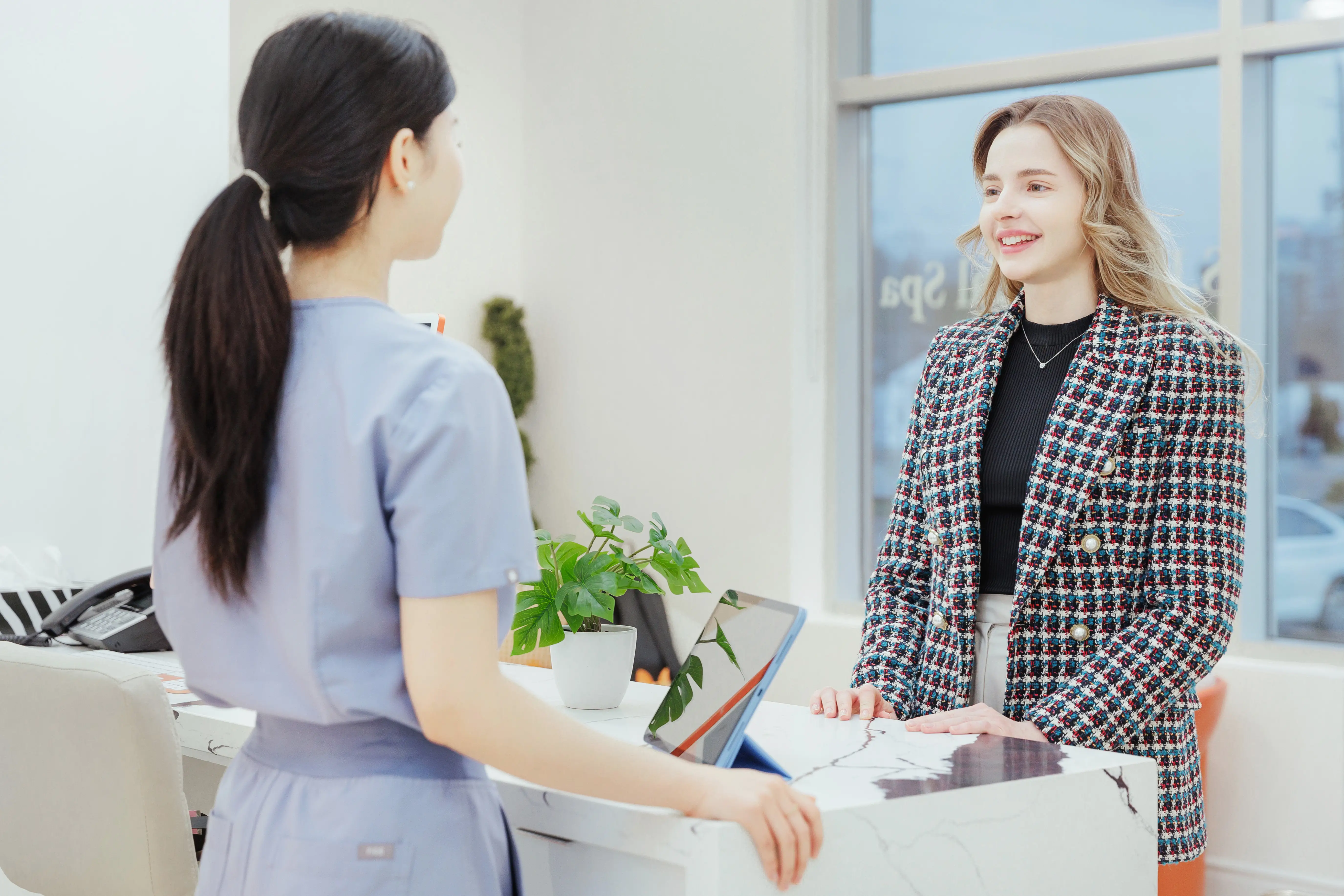 A client and a nurse talking at the front desk of S.D. Medical Spa in Oakville.