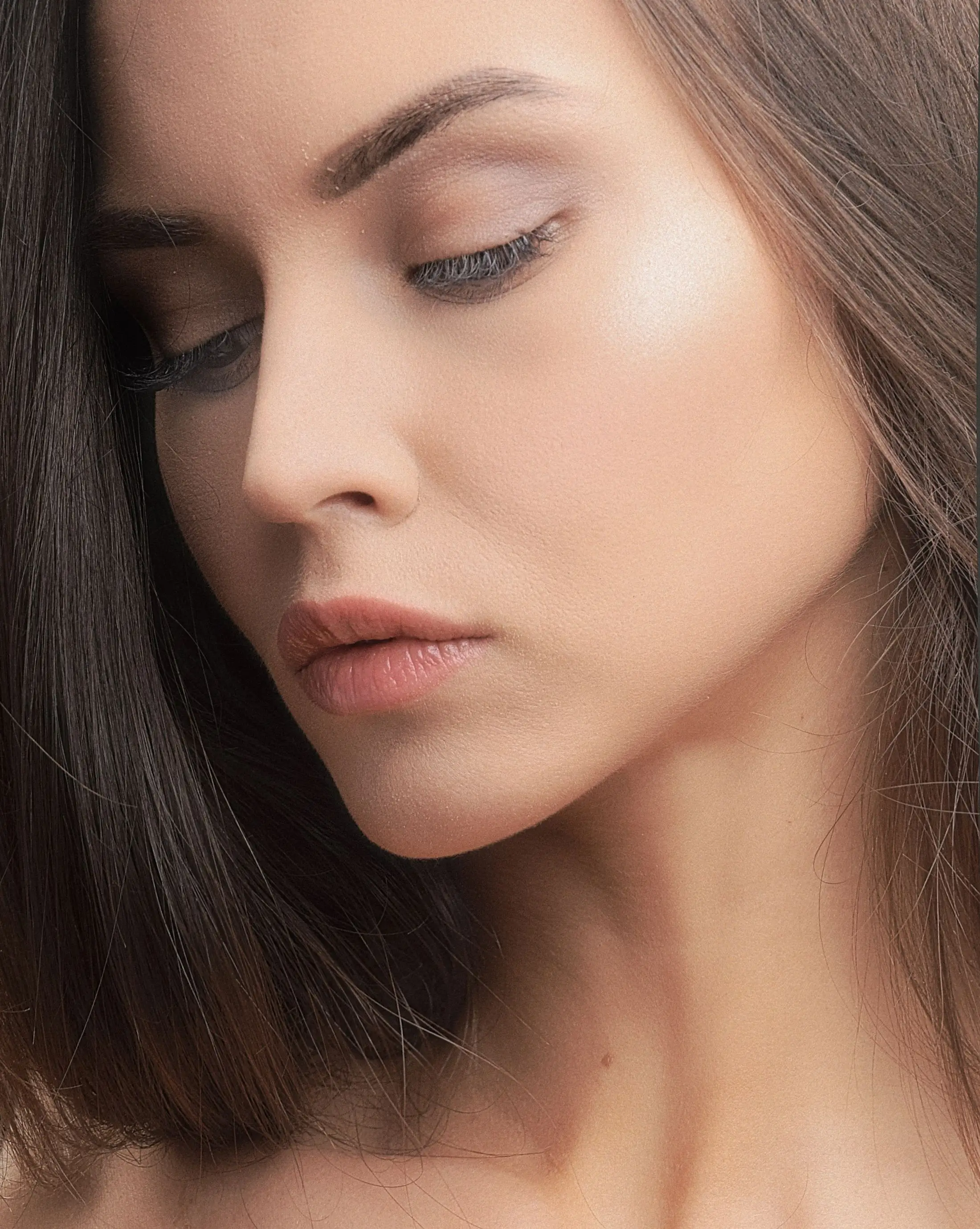 A close view of a face, with eyes lowered.